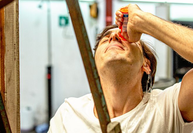 Homem utilizando a solução Diphoterine® para uma descontaminação ocular após exposição química